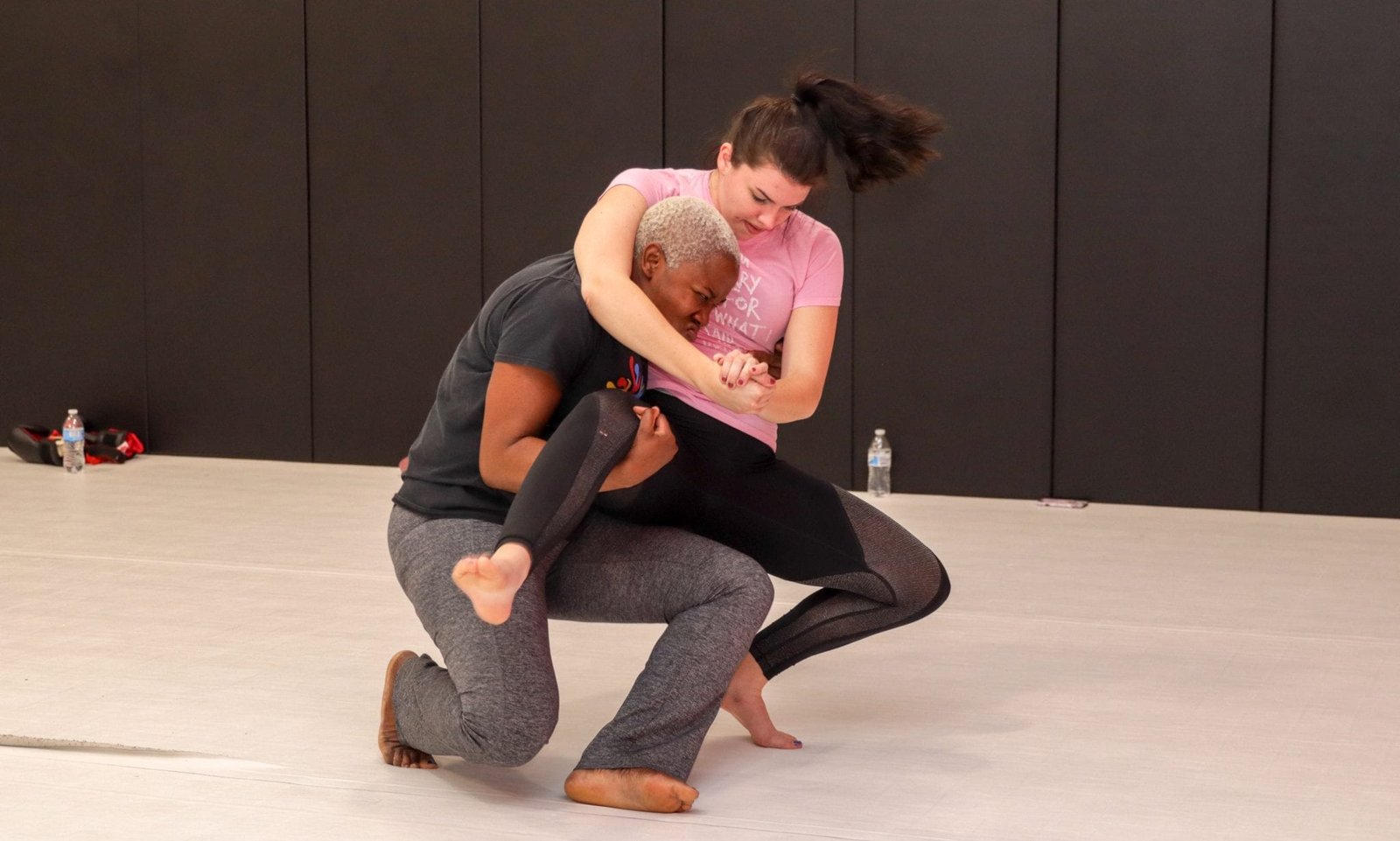 two women learning grappling moves
