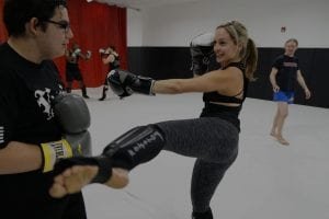 man and woman sparring muay thai darkened image